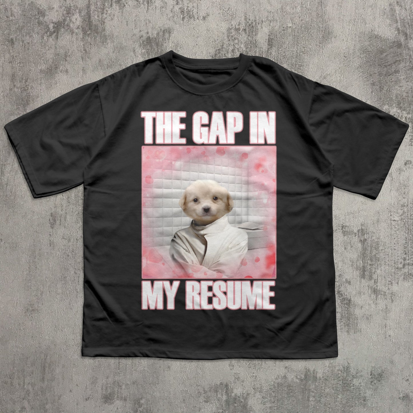 Black t-shirt with a graphic of a dog and text 'The gap in my resume' on a concrete surface.