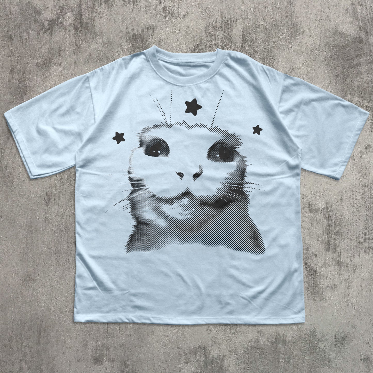 White t-shirt with a black and white cat graphic on a textured gray surface