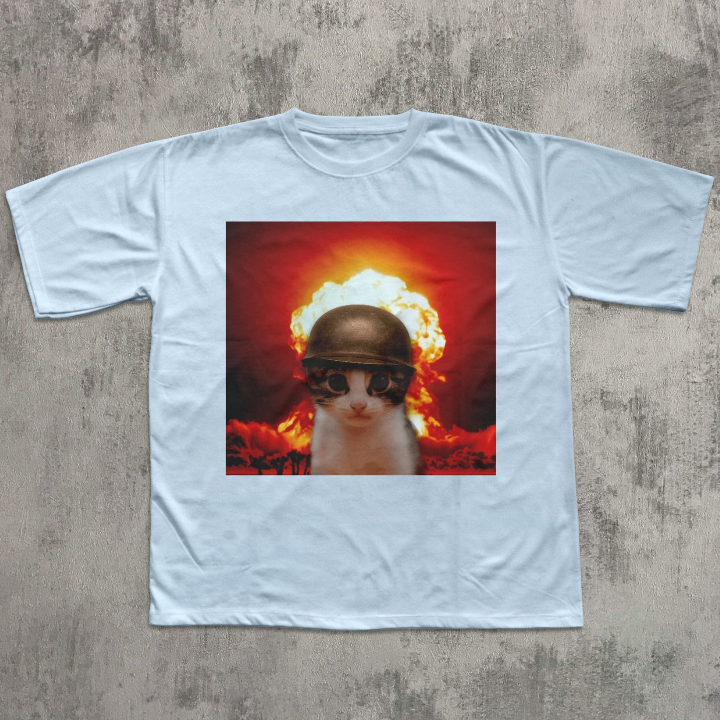 White t-shirt with a graphic of a cat wearing a helmet and goggles in front of an explosion on a concrete surface.