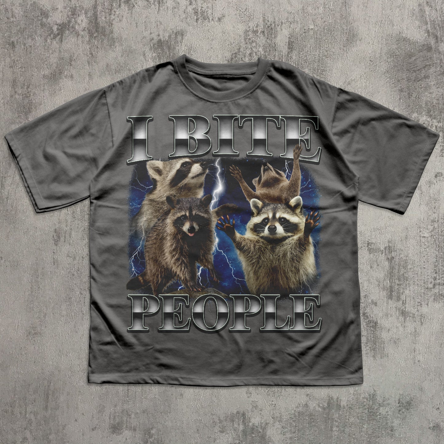 Gray t-shirt with raccoon graphic and text 'I BITE PEOPLE' on a textured gray background