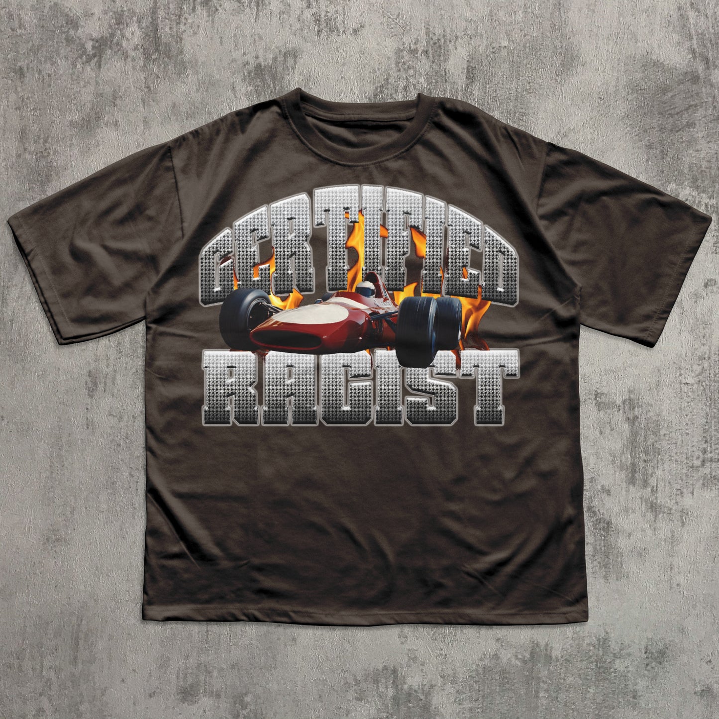 Brown t-shirt with a graphic of a race car and flames on a concrete surface