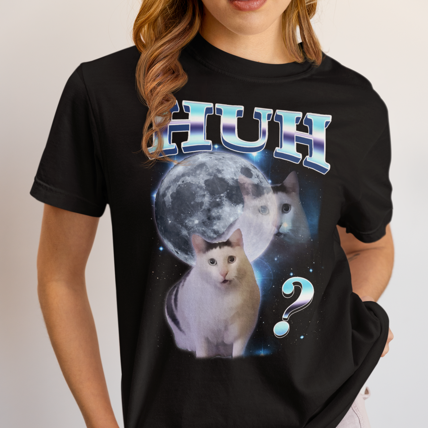 Black t-shirt with a graphic of two cats and a moon, featuring the word 'HUH' and a question mark.