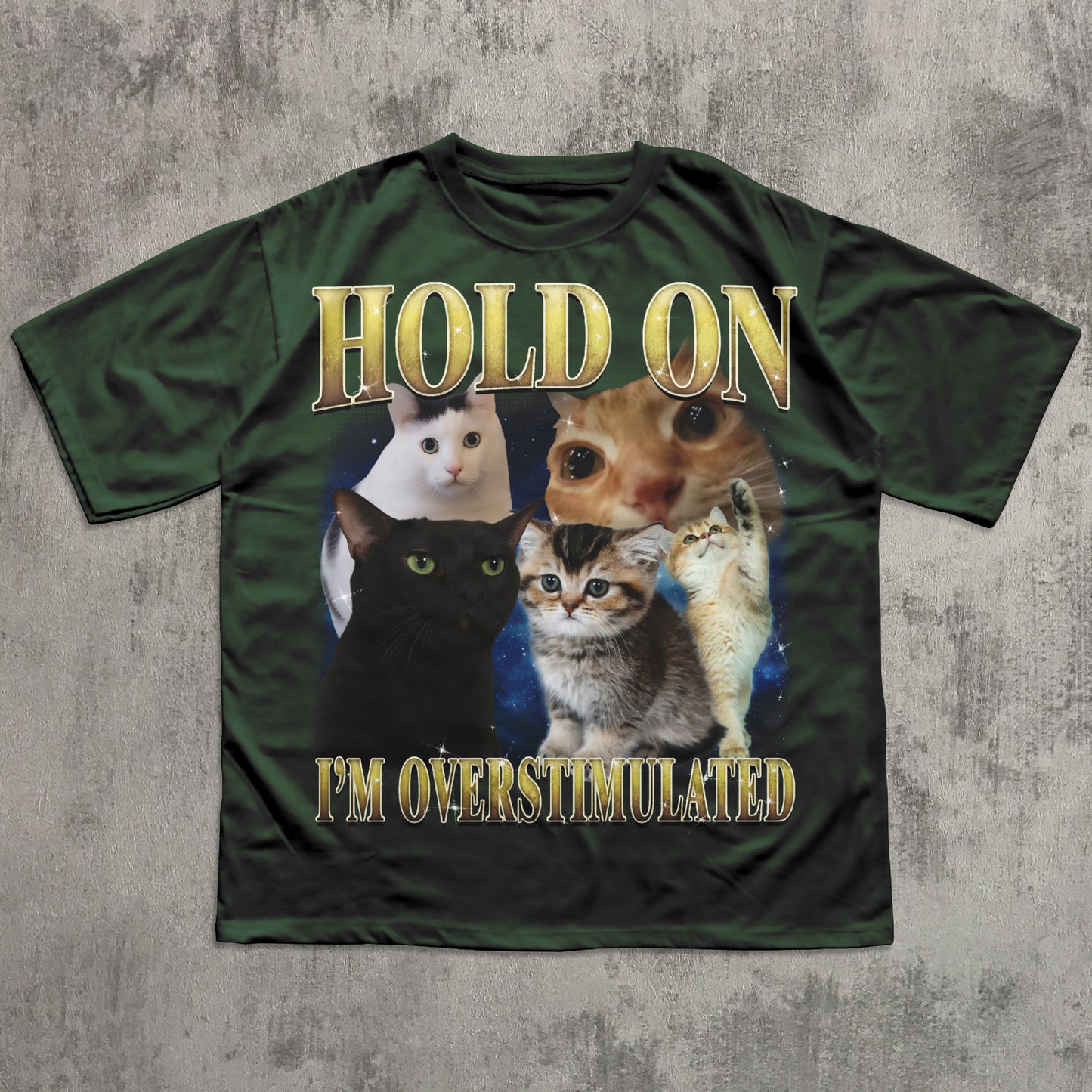 Green t-shirt with cats and text 'Hold on I'm overstimulated' on a textured gray background