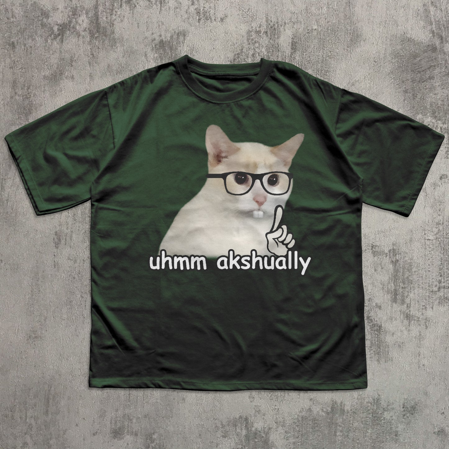 Funny Green t-shirt with a cat graphic and text 'uhmm akshually' on a textured gray background
