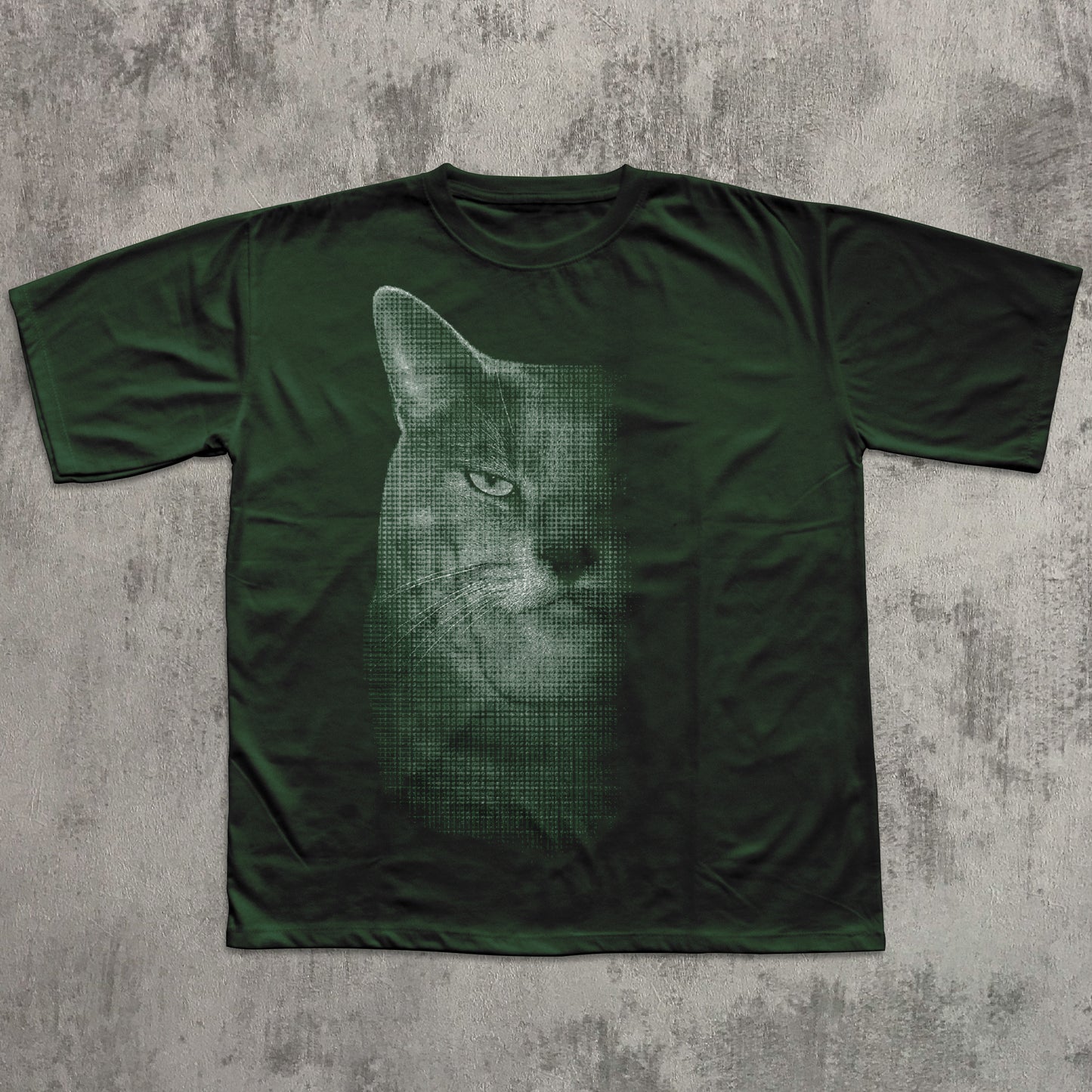 Green t-shirt with a cat graphic on a textured gray surface