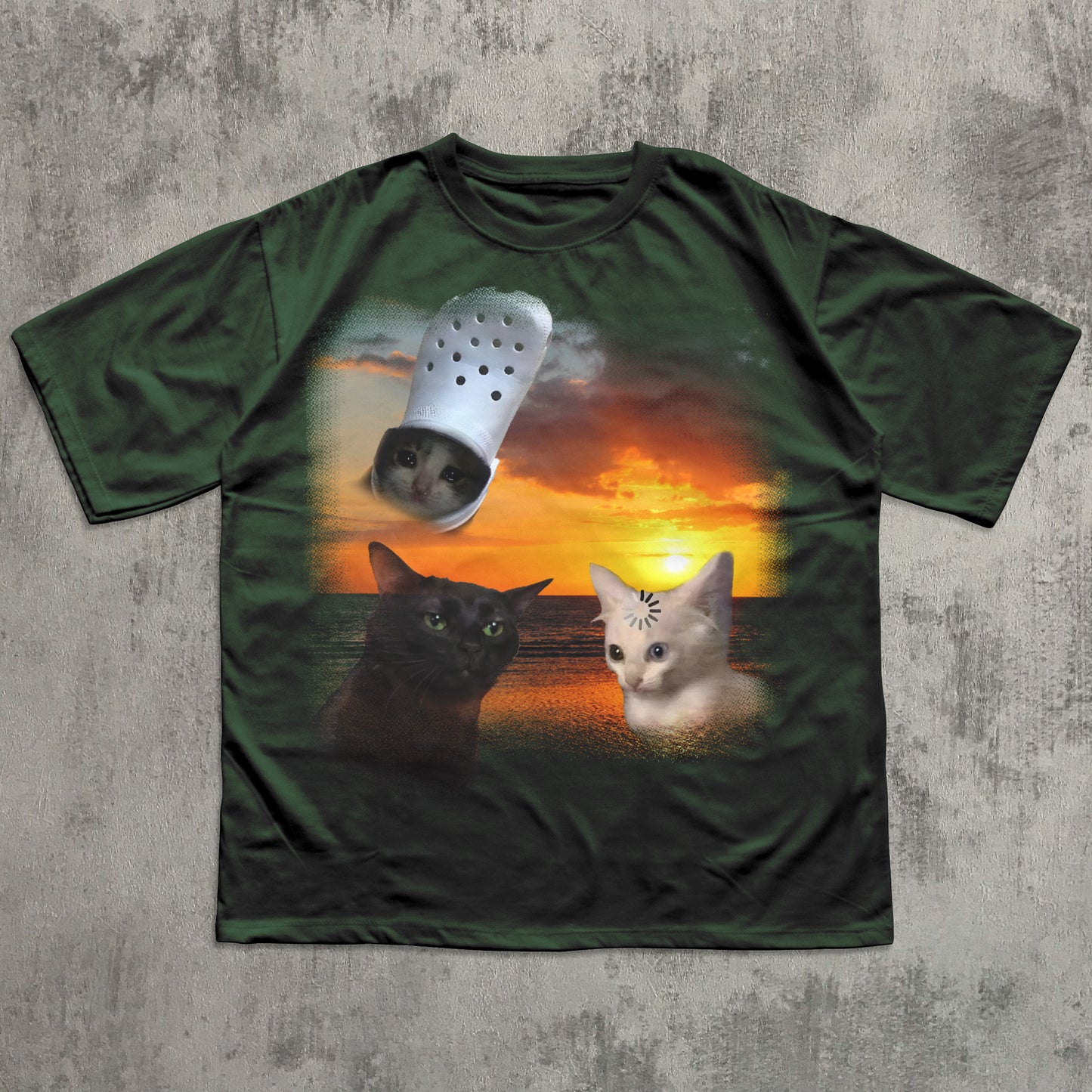 Green t-shirt with a graphic of two cats and a Croc shoe on a sunset background