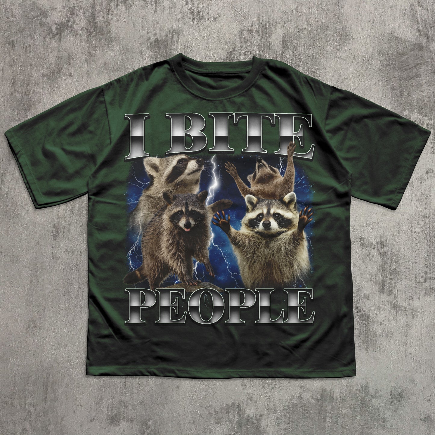 Green t-shirt with raccoon graphic and text 'I BITE PEOPLE' on a textured gray background