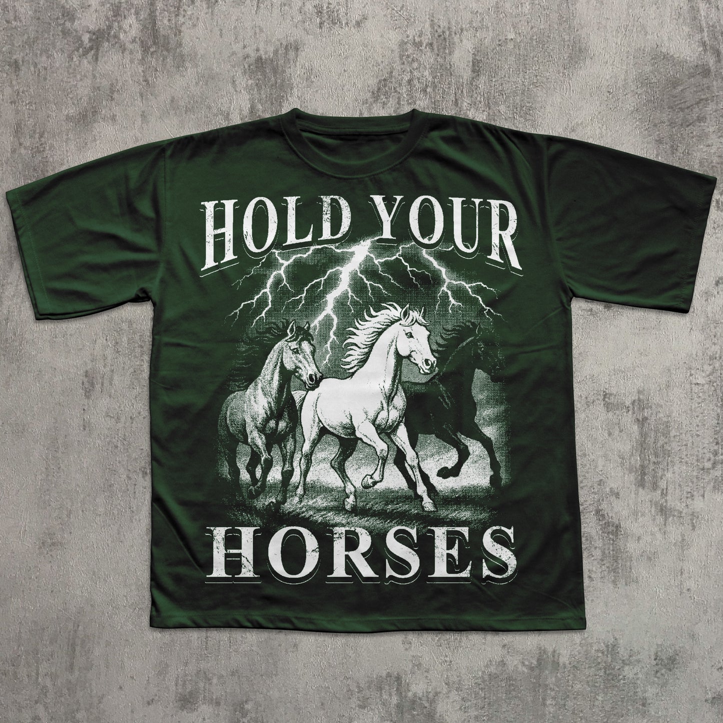 Green t-shirt with graphic of horses and 'Hold Your Horses' text on a textured gray background