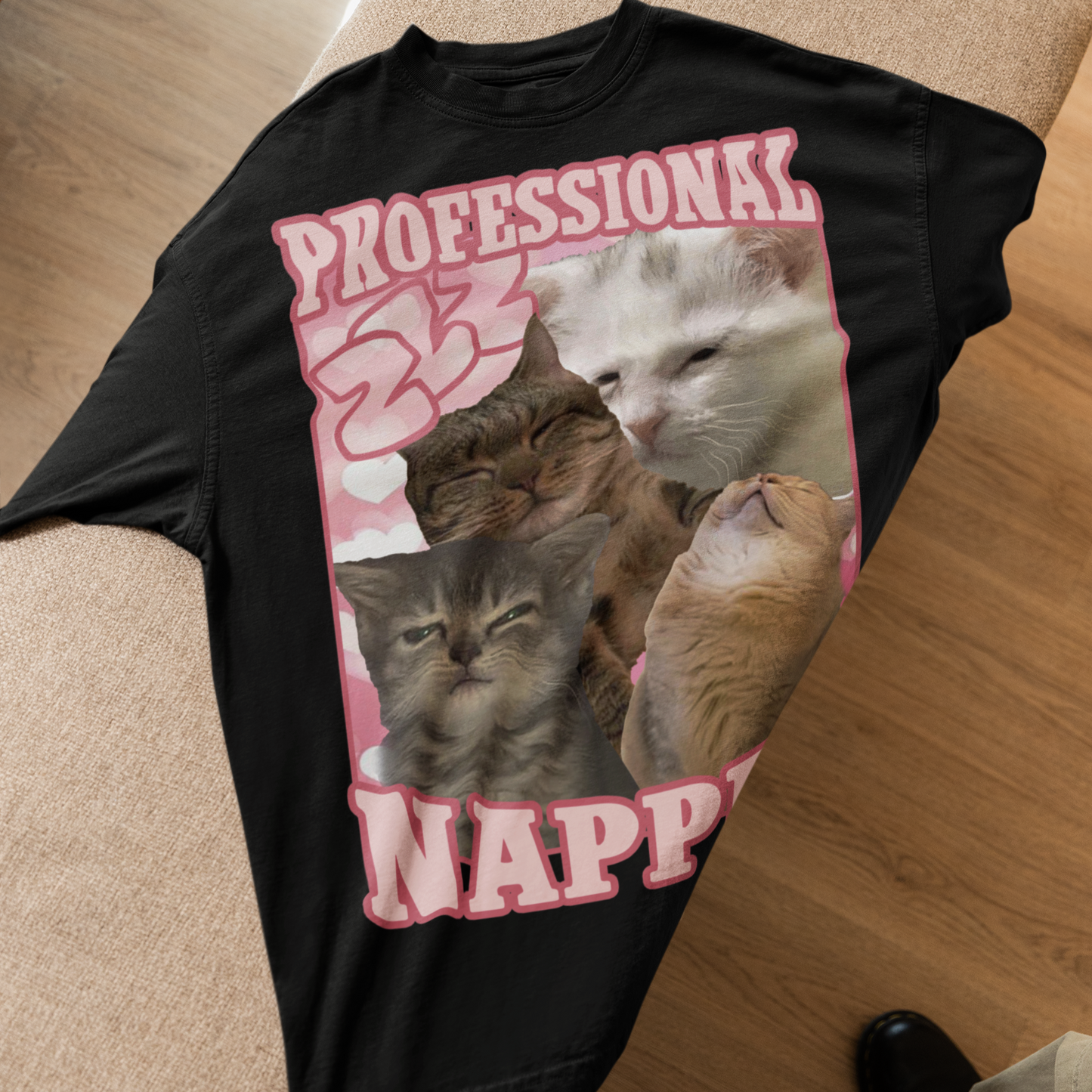 Black t-shirt with cat graphic and text 'Professional Napper' on a wooden floor.