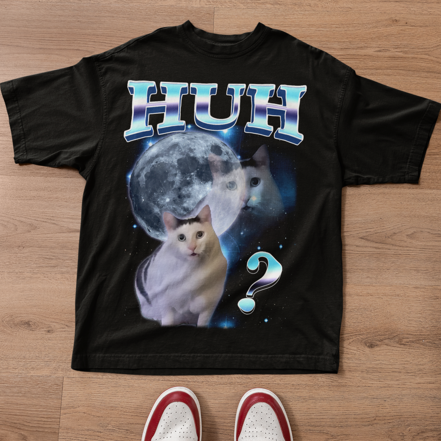 Black t-shirt with a cat graphic and text on a wooden surface