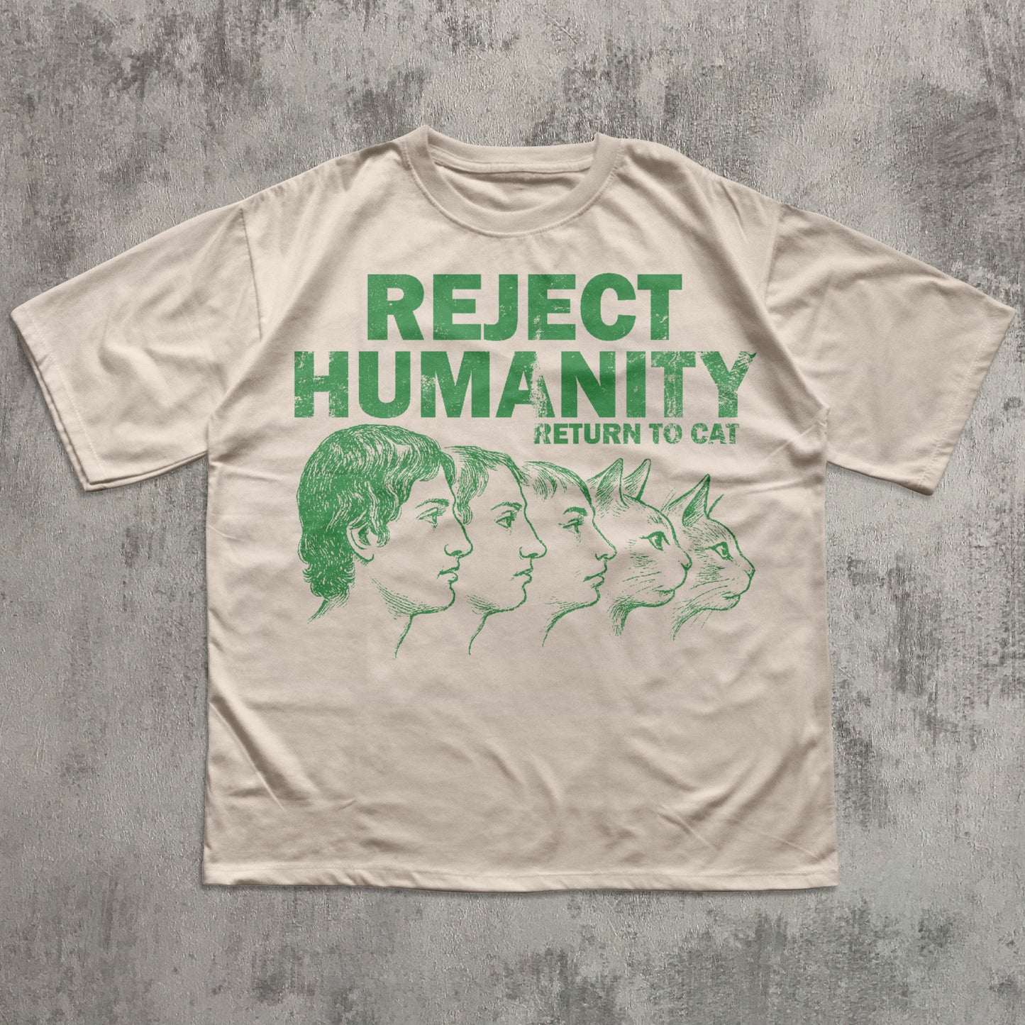 Beige t-shirt with green text and graphic on a textured gray background