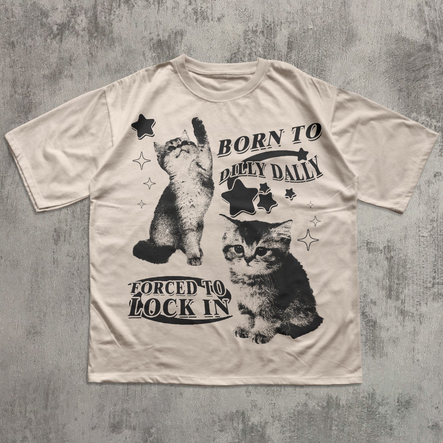 Beige t-shirt with black cat graphics and text on a textured gray background