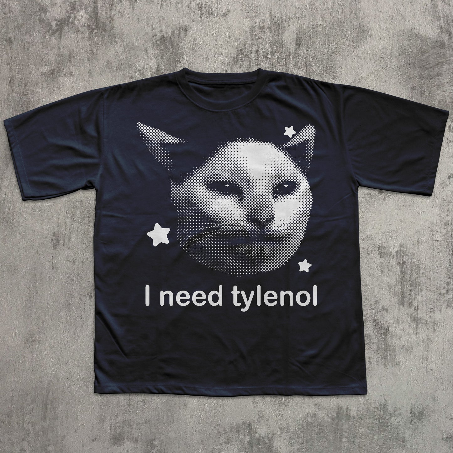 Black t-shirt with a cat graphic and 'I need tylenol' text on a textured gray background