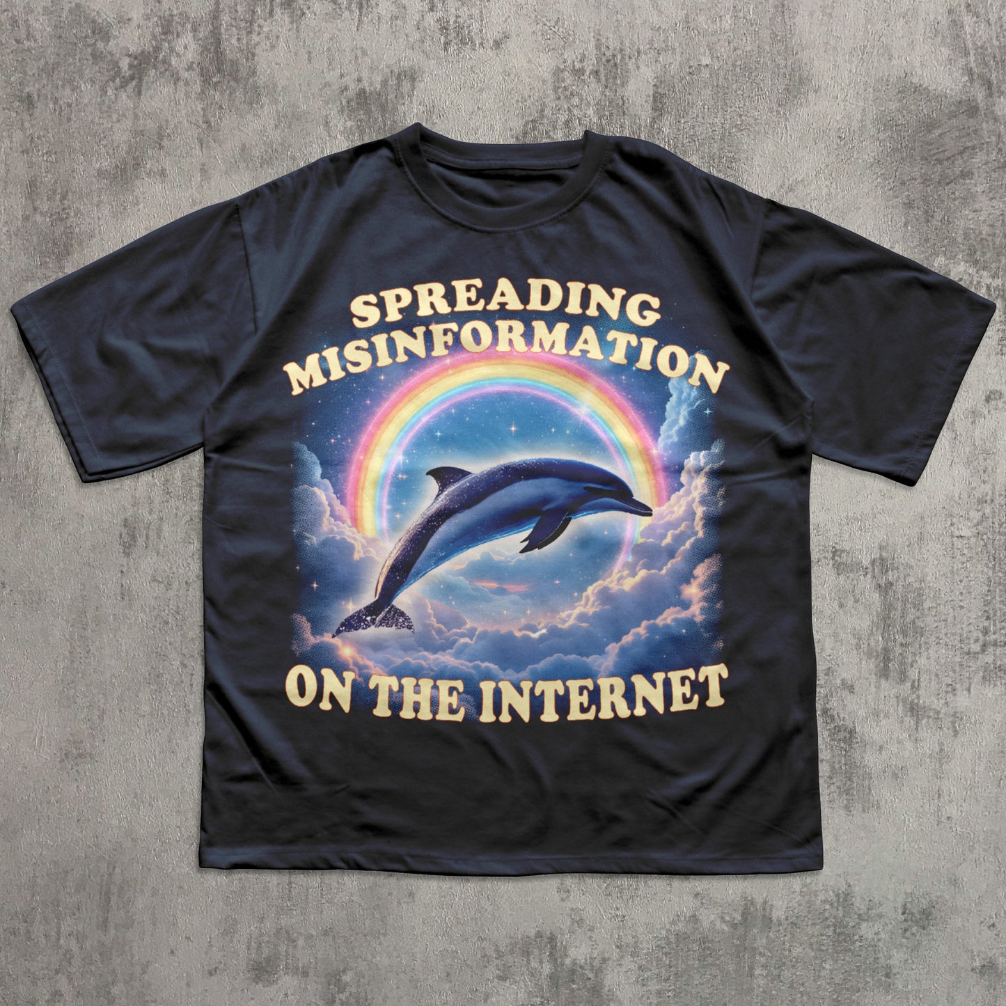 Black t-shirt with a dolphin and rainbow graphic and text on a concrete surface