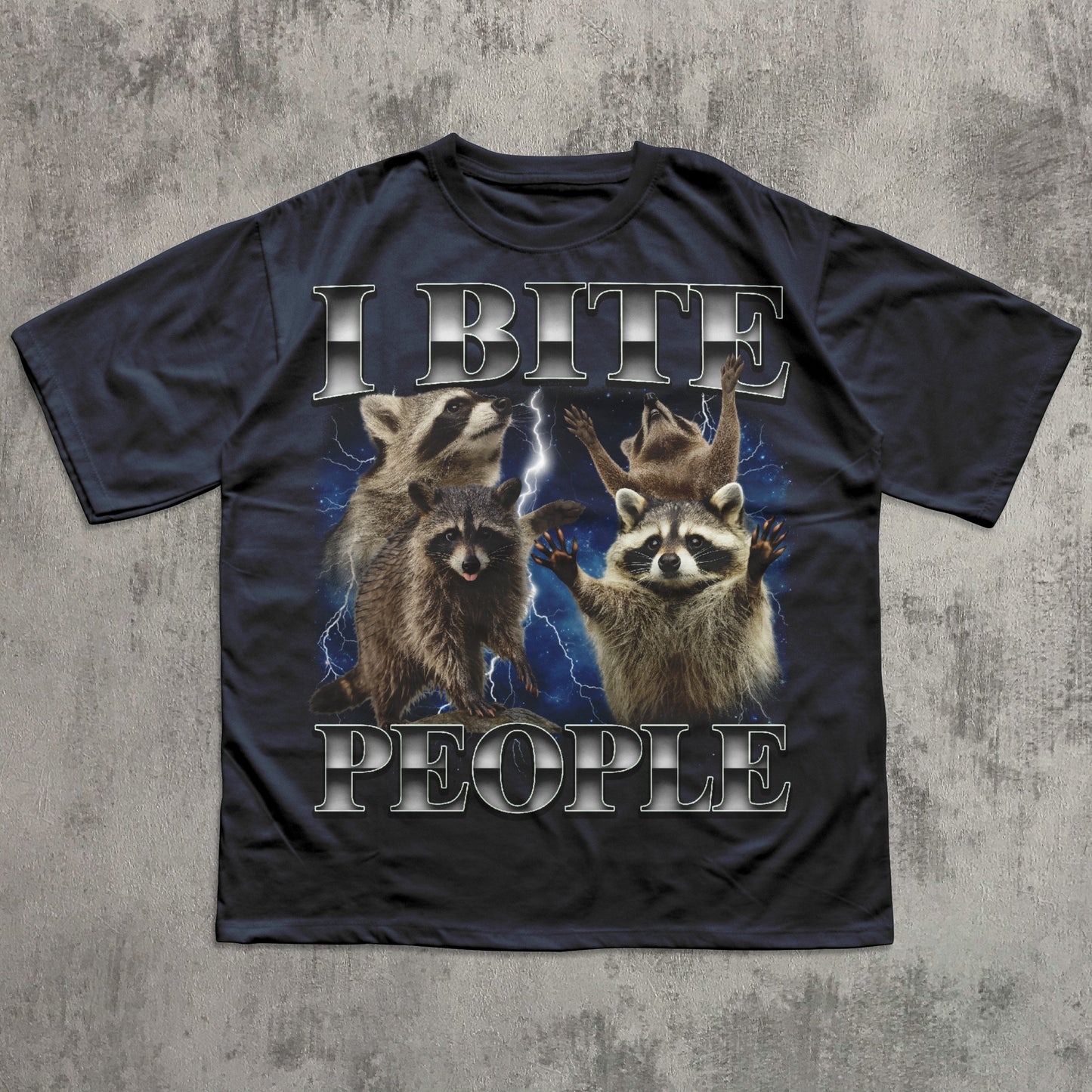 Black t-shirt with raccoon graphic and text 'I BITE PEOPLE' on a textured gray background