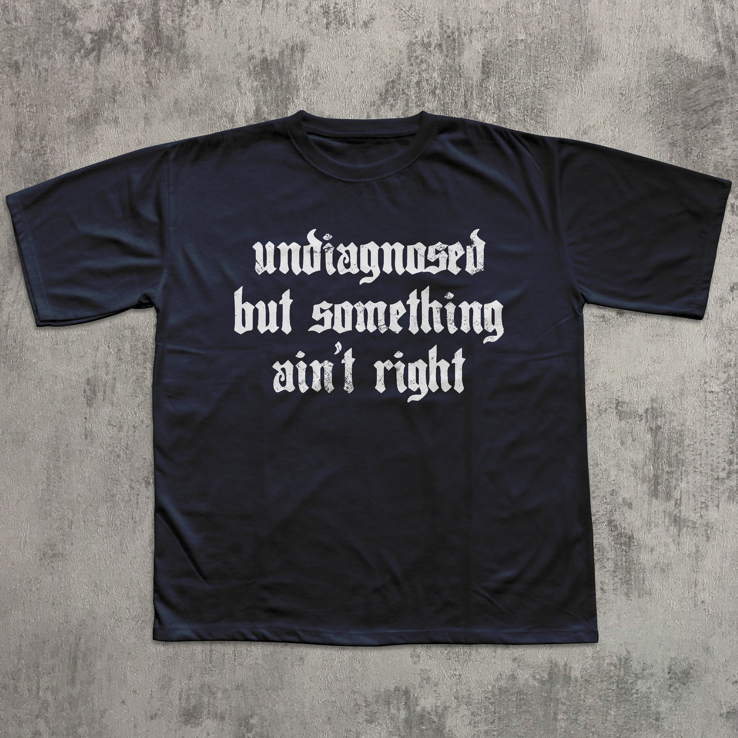 Black t-shirt with white text on a textured gray background
