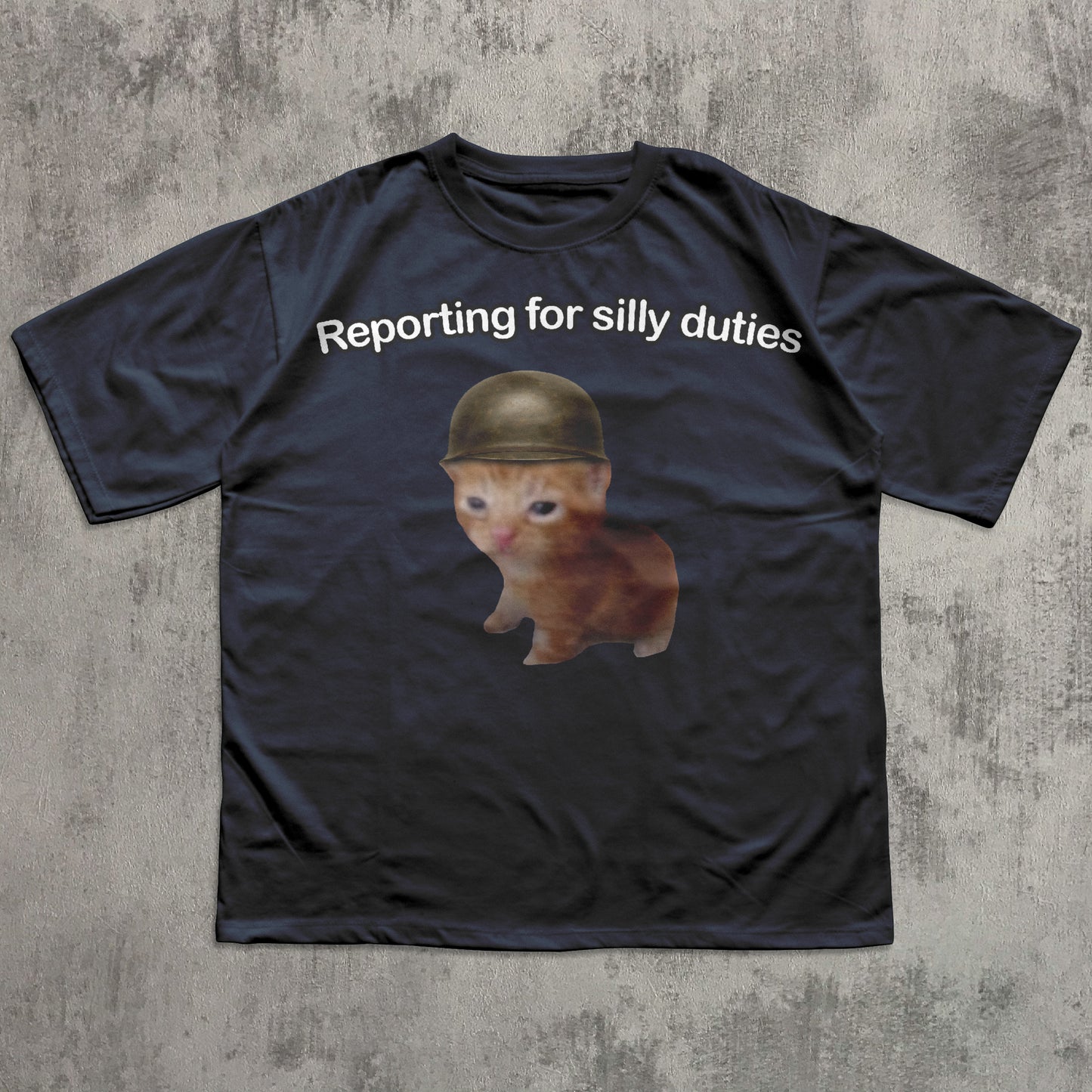 Black t-shirt with a cat wearing a helmet and text 'Reporting for silly duties' on a textured gray background