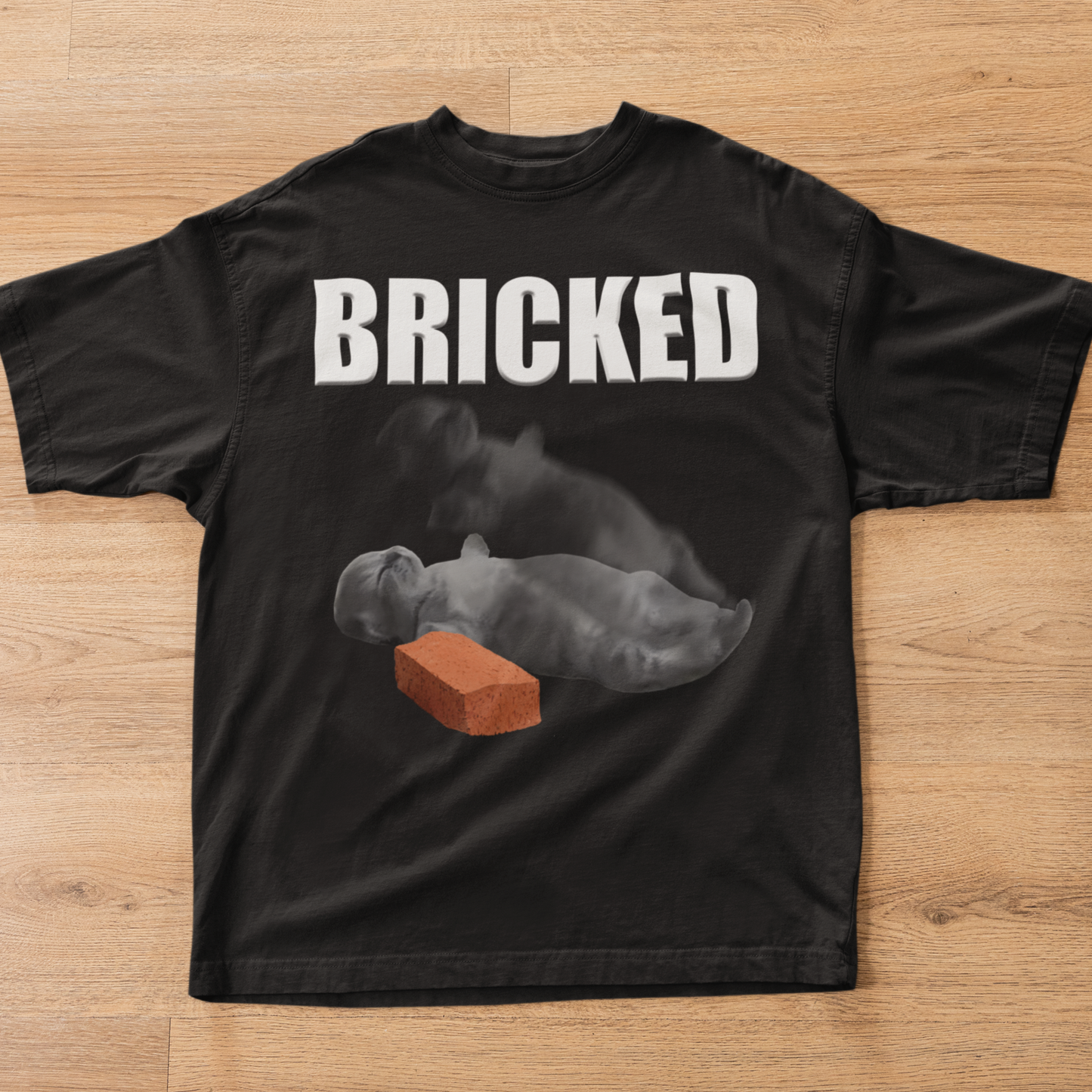 Black t-shirt with 'BRICKED' text and graphic of a Cat with a brick on a wooden surface