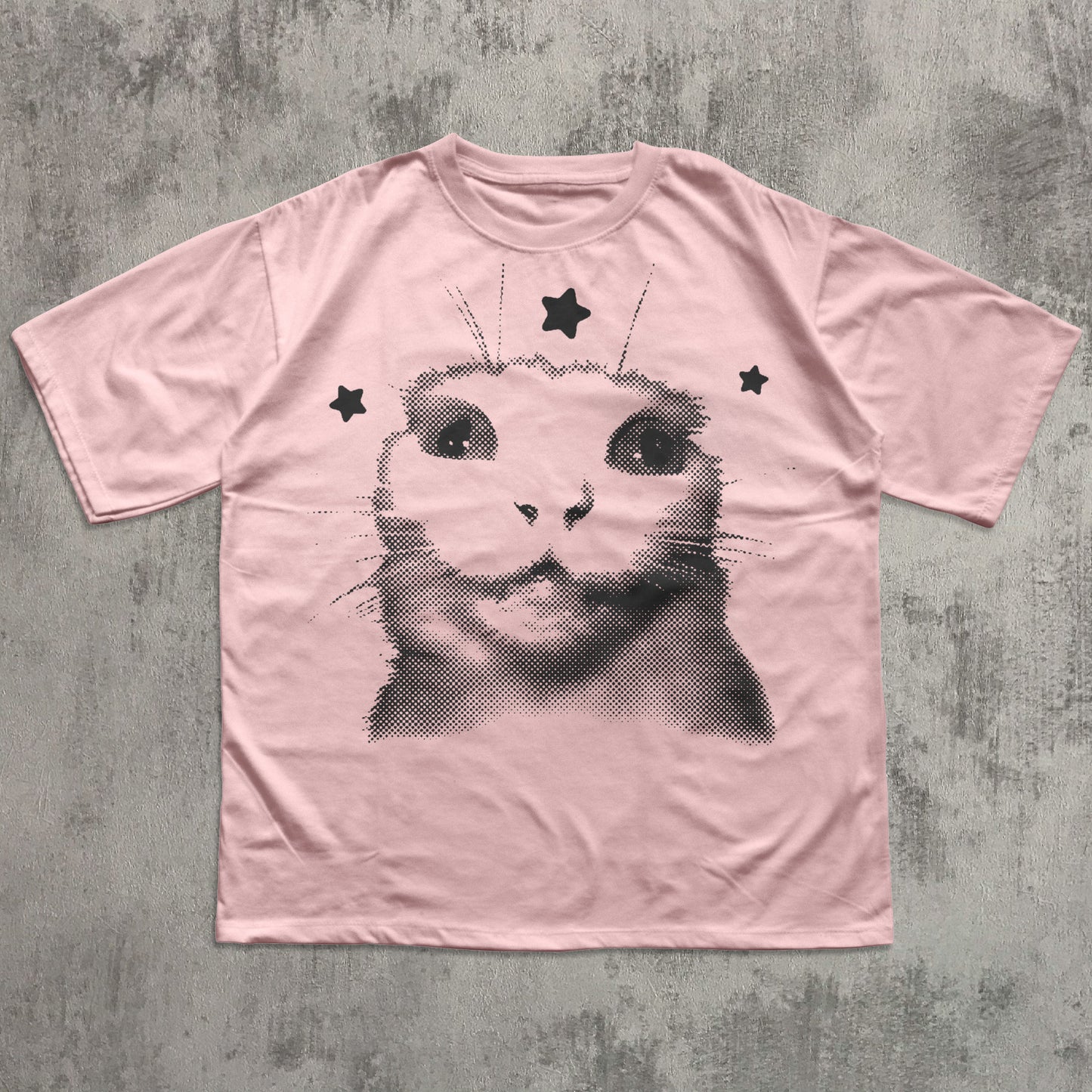 Pink t-shirt with a black cat graphic on a textured gray background