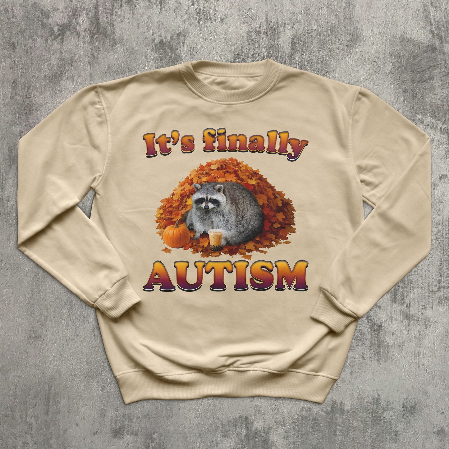 Beige sweatshirt with raccoon and autumn design on a textured gray background