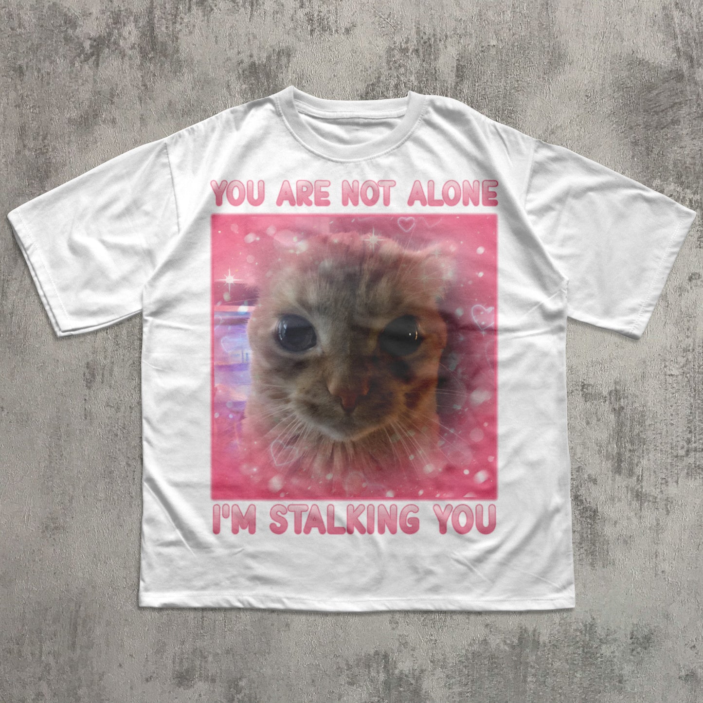 funny White t-shirt with a cat graphic and text on a concrete surface