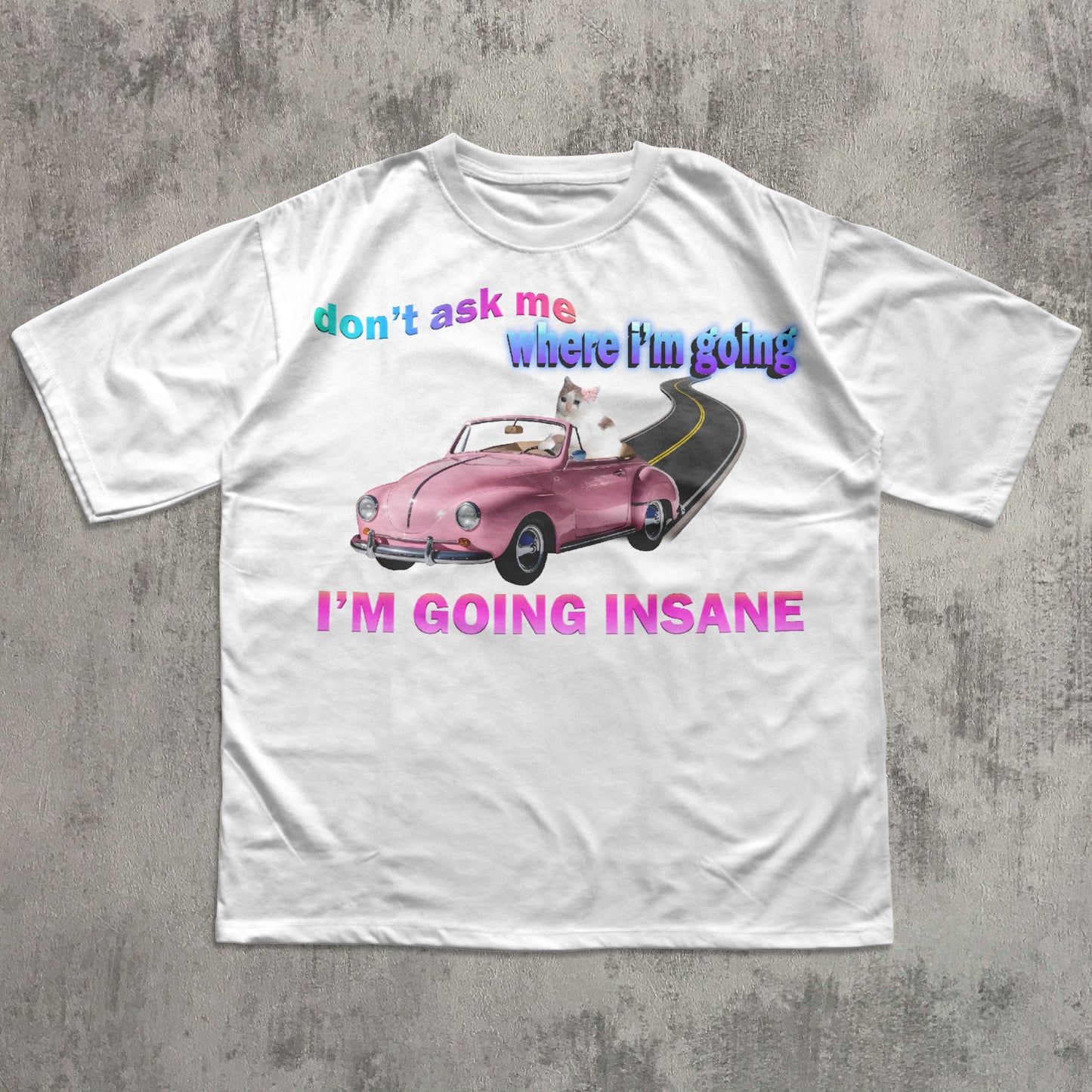 Funny cat meme white t-shirt with a graphic of a cat in a car and text on a concrete surface