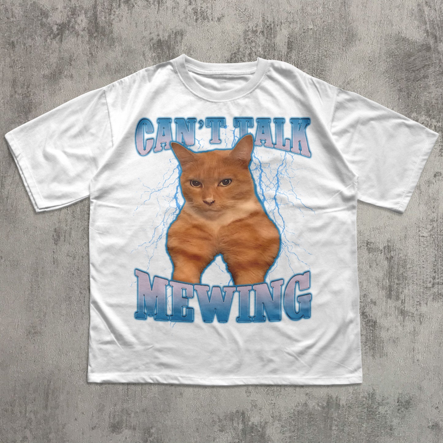 Funny White t-shirt with a graphic of a cat and text 'CAN'T TALK MEOWING' on a concrete surface.