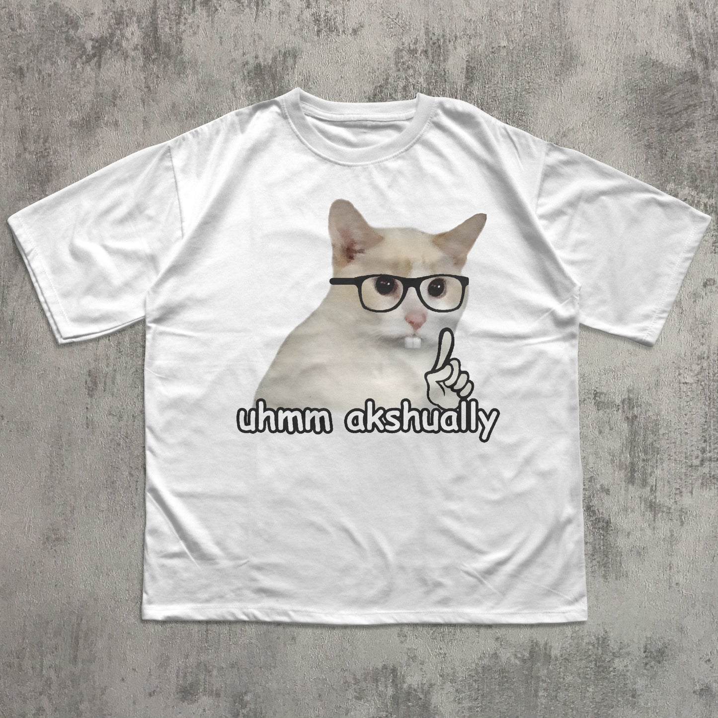 Funny White t-shirt with a cat graphic and text 'uhmm akshually' on a textured gray background