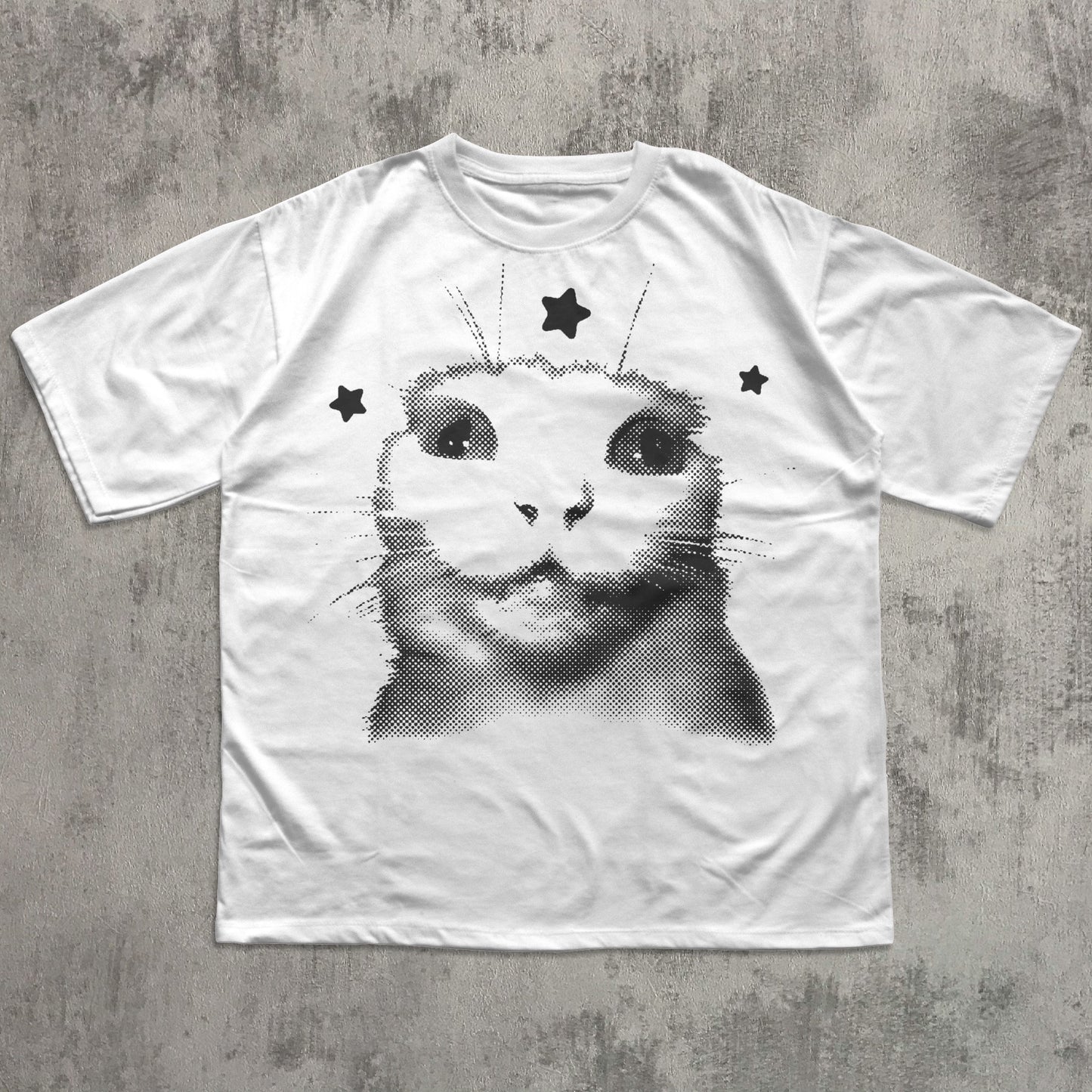 White t-shirt with a black and white cat graphic on a gray concrete surface