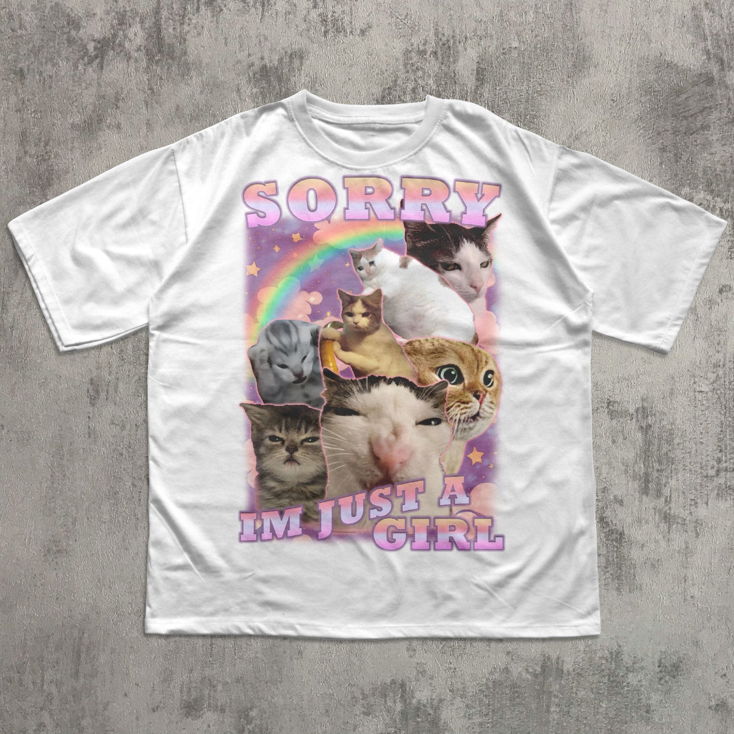 White t-shirt with cat collage and rainbow text on a concrete surface