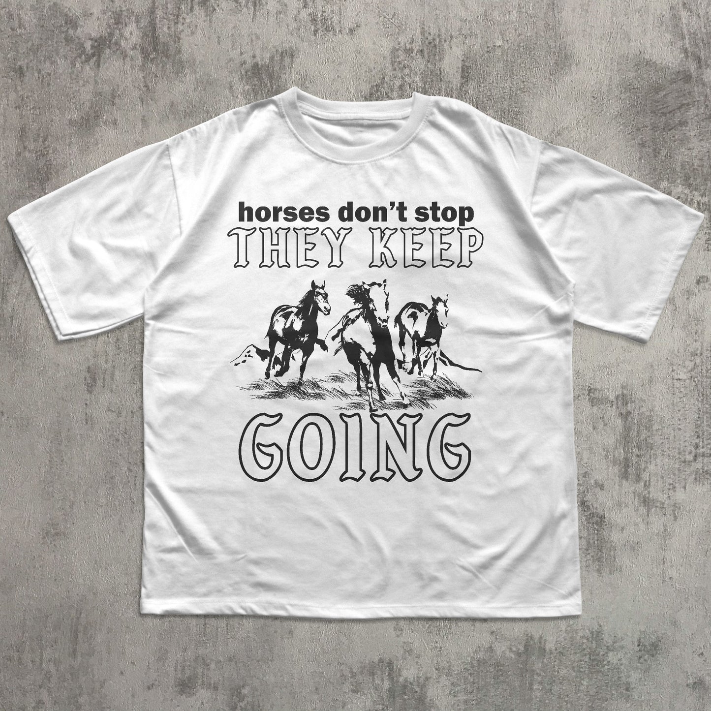 White t-shirt with graphic horse design and text on a textured gray background