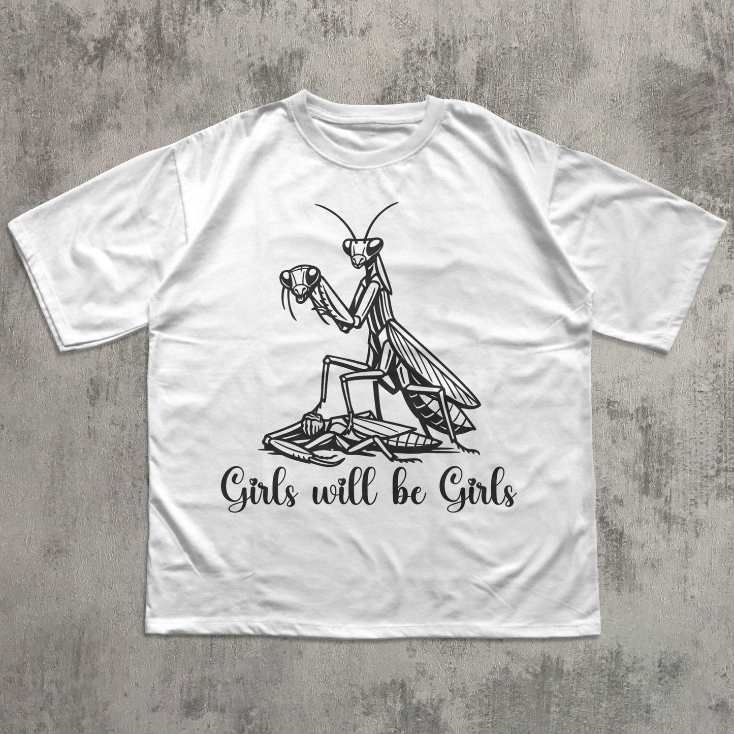 White t-shirt with a praying mantis graphic and text on a concrete surface