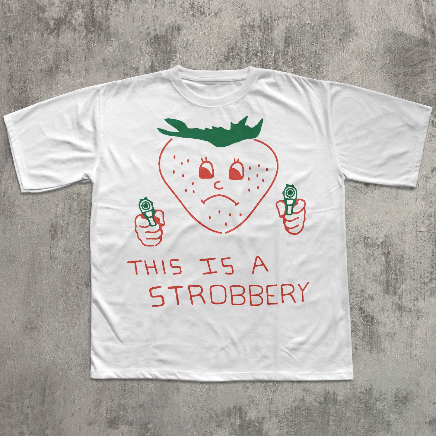 White t-shirt with a strawberry graphic and text on a concrete surface