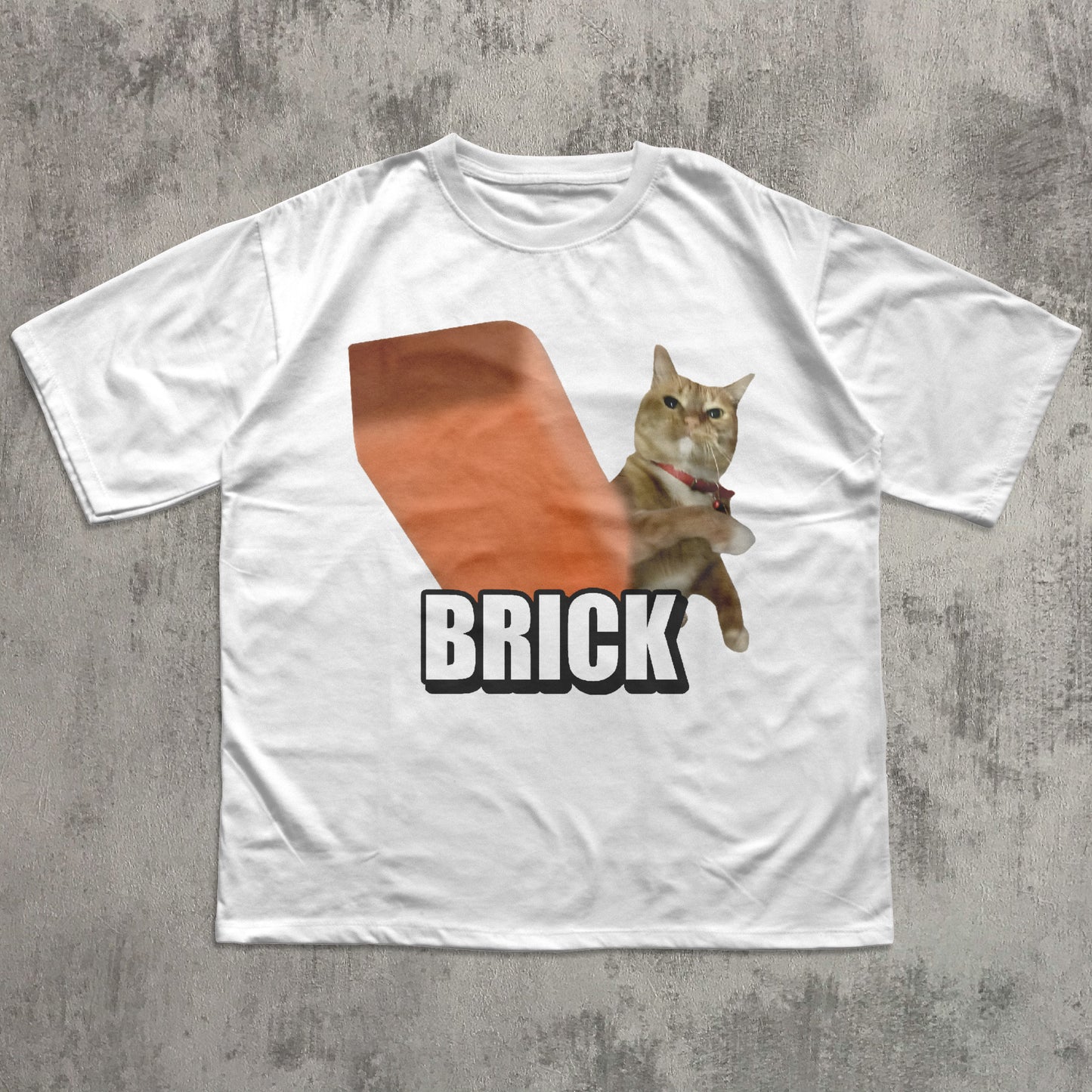 White t-shirt with a graphic of a cat holding a brick and the word 'BRICK' on a concrete surface.