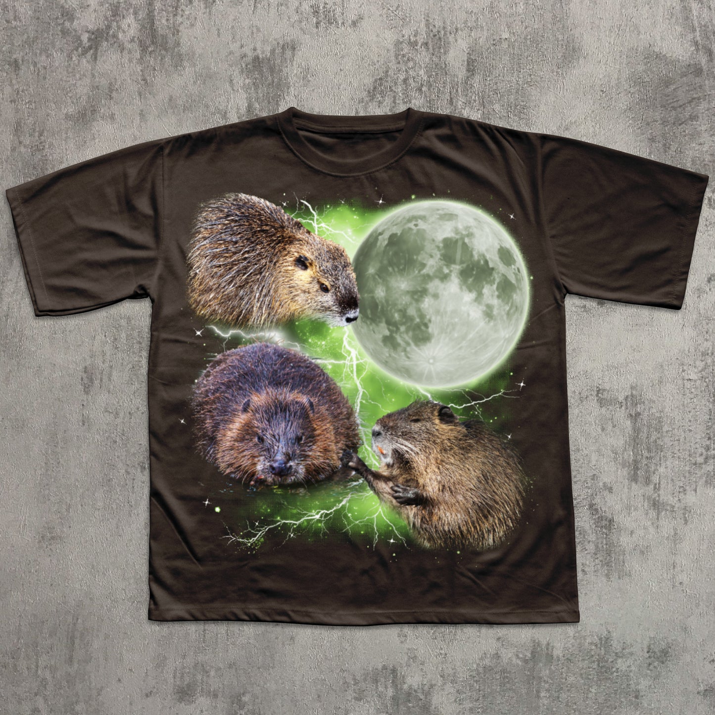 Brown graphic T-shirt featuring three realistic beavers arranged around a glowing full moon with green lightning effects in the background.