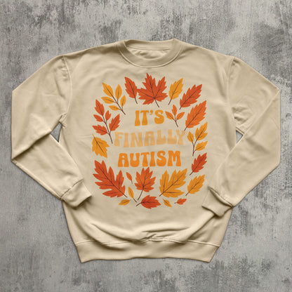 Beige sweatshirt with autumn leaf design and text on a gray textured background