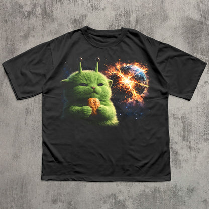 Black t-shirt with a green creature holding a corn on a concrete surface