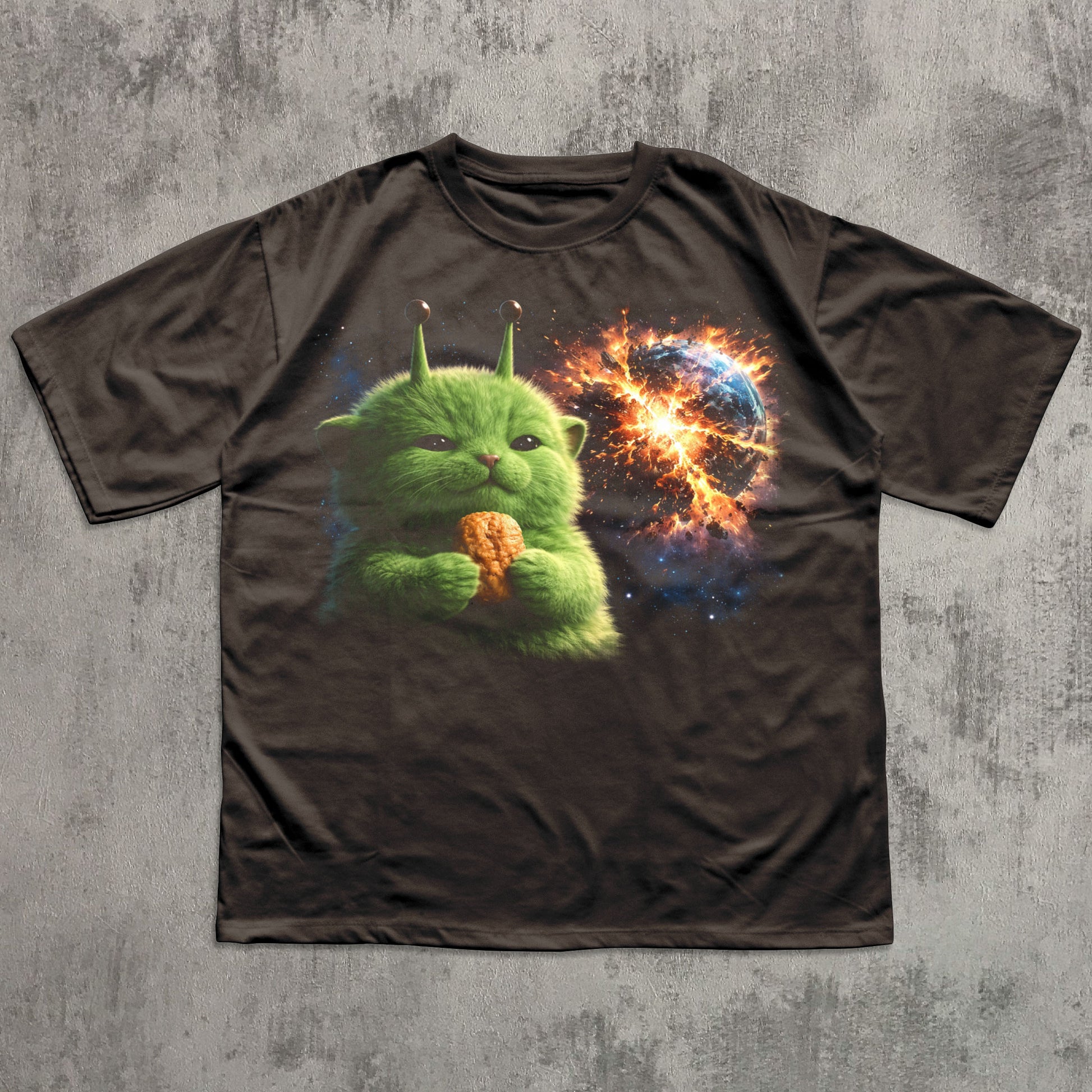 Brown t-shirt with a green alien holding a nugget design on a textured gray background