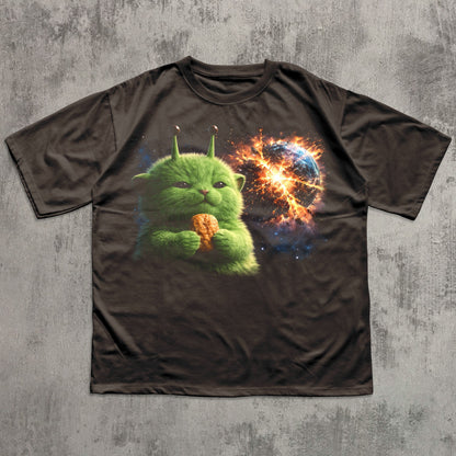 Brown t-shirt with a green alien holding a nugget design on a textured gray background