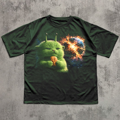 Green t-shirt with a fantasy creature and cosmic design on a textured gray background