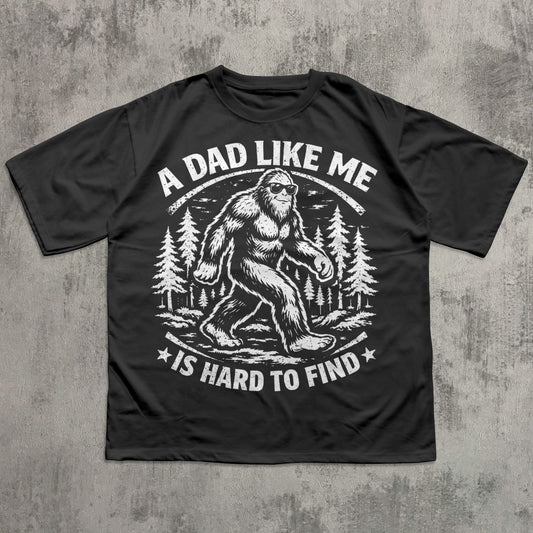 Black funny Bigfoot dad T-shirt featuring vintage Sasquatch graphic in forest with sunglasses and slogan “A Dad Like Me Is Hard to Find” – novelty Father’s Day gift tee for outdoorsy dads