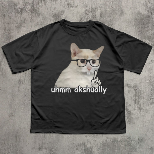 Black t-shirt with a cat graphic and text 'uhmm akshually' on a textured gray background