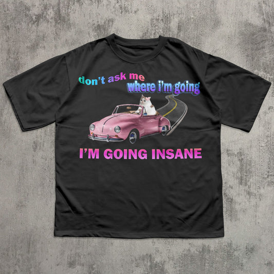 Funny cat meme black t-shirt with a pink car graphic and text on a concrete surface