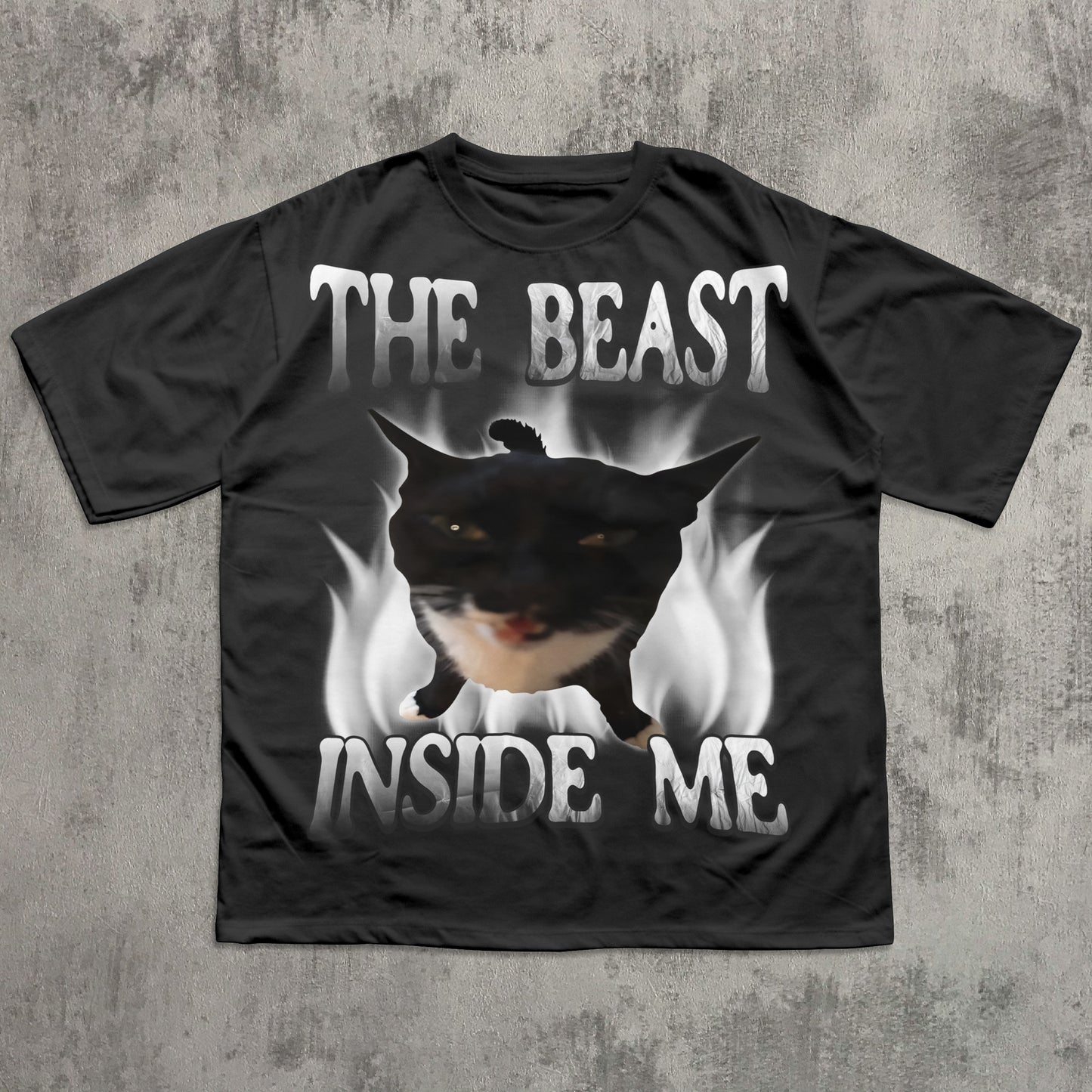 Black t-shirt with a graphic of a dog and text 'The Beast Inside Me' on a concrete surface.