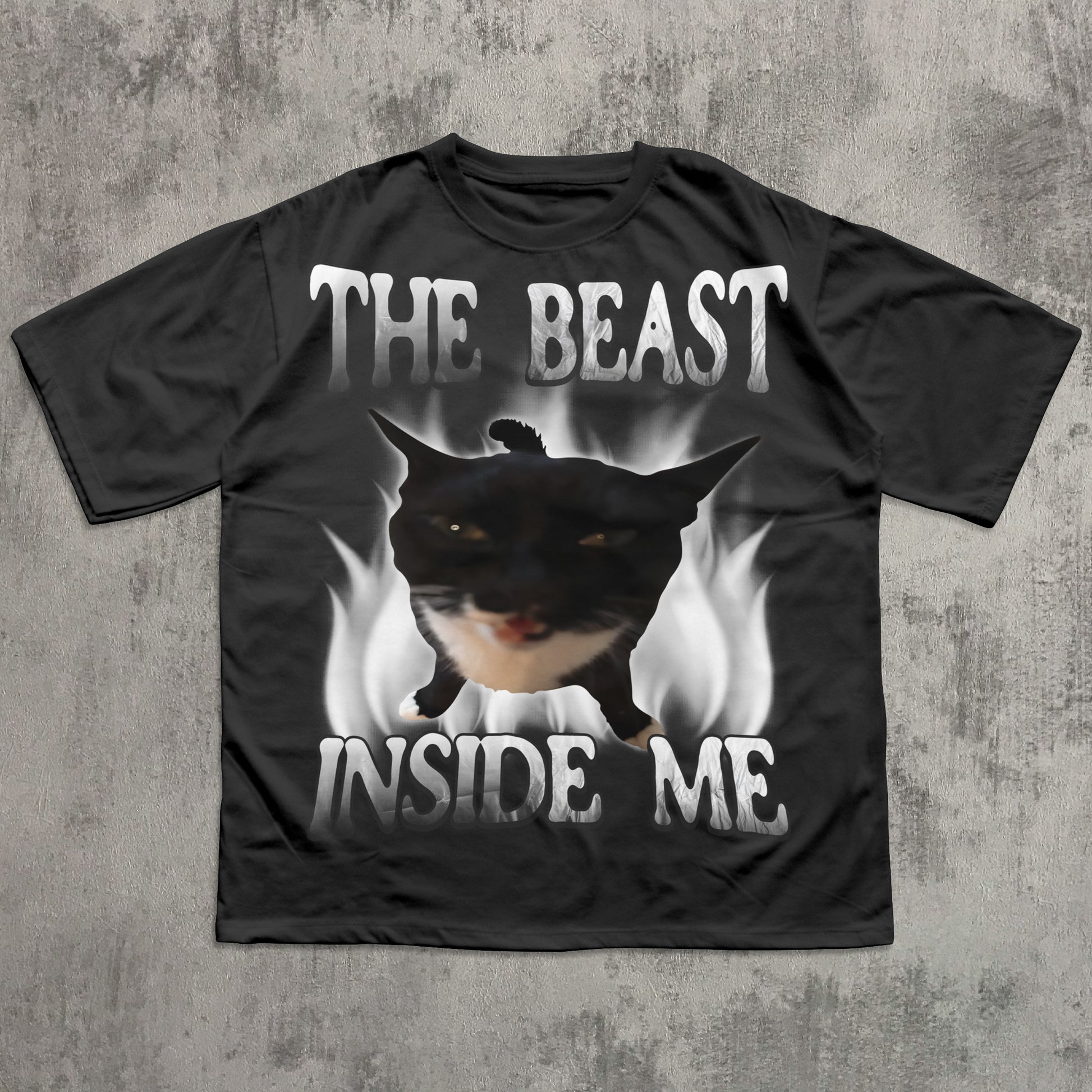 Black t-shirt with a graphic of a dog and text 'The Beast Inside Me' on a concrete surface.