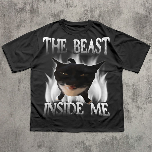 Black t-shirt with a graphic of a dog and text 'The Beast Inside Me' on a concrete surface.