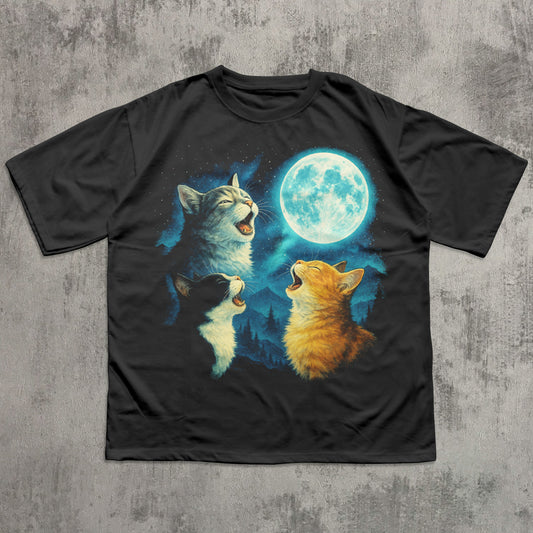 Black t-shirt with a graphic of three meowing cats under a moonlit sky on a textured gray background.