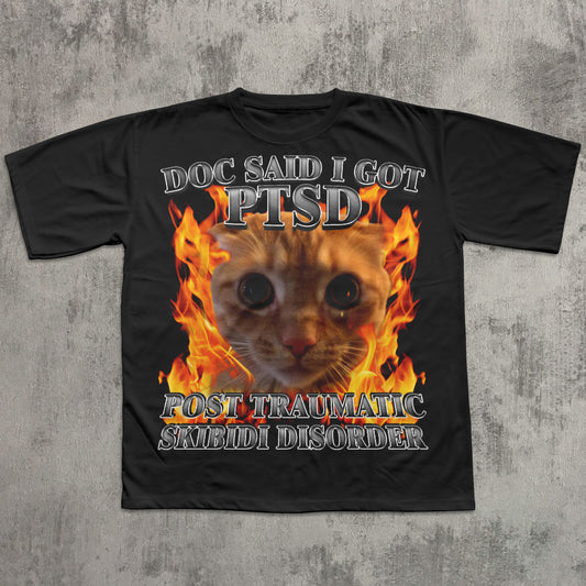 Black t-shirt with a cat graphic and text on a concrete surface