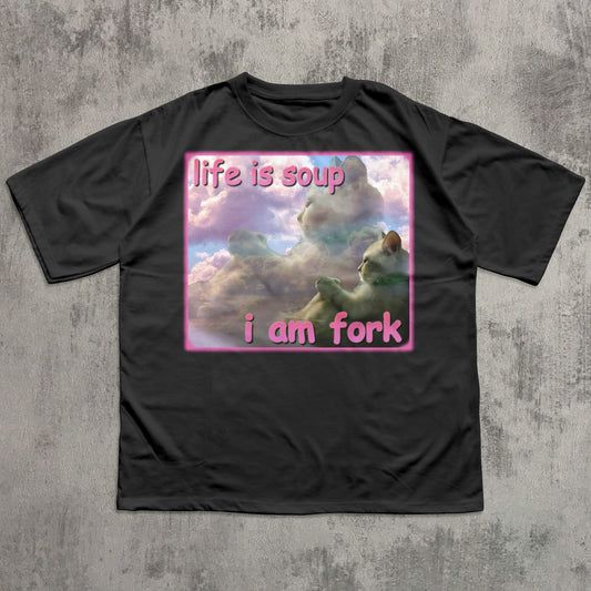 Black t-shirt with a graphic design of a cat in clouds and text 'life is soup i am fork' on a textured gray background.