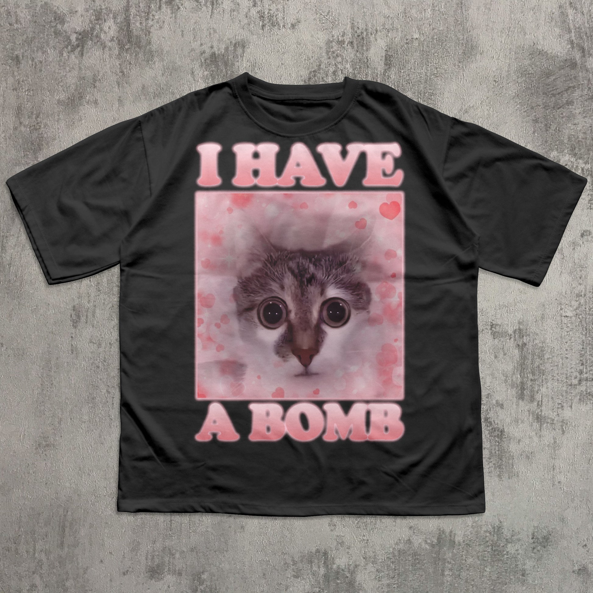 Black t-shirt with a graphic of a cat and text 'I HAVE A BOMB' on a textured gray background